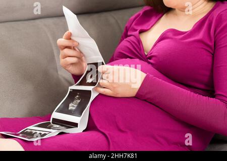 Prise de vue d'une femme enceinte regardant une image d'un échogramme à la maison Banque D'Images