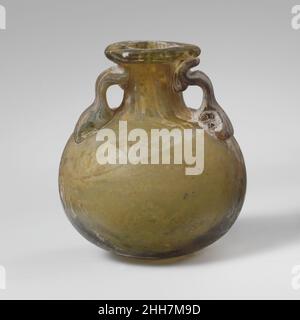 Aryballos en verre (bouteille d'huile) mi-1st–3rd Century A.D. fond d'huile romain à parois épaisses vert translucide jaune-translucide; poignées de la même couleur.rebord replié, sur-dessus et à l'intérieur et aplati sur le dessus; col cylindrique, évasant à la base pour joindre le squat, corps globulaire; fond arrondi;Deux poignées appliquées sur le dessus du corps dans de grands coussins, tracées, pliées et pressées sur le dessus du cou et le dessous de la jante.corps intact, mais une poignée cassée et réparée; une grande puce manquante dans la jante; puce avec des bris manquants dans le coussinet inférieur de chaque poignée;quelques bulles et inclusions vitreux; morcellement, piqûres et irid Banque D'Images