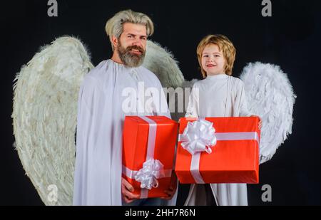 Les anges de Saint-Valentin avec le présent.Père et fils heureux avec boîte cadeau.cupidon de Saint-Valentin avec ailes blanches. Banque D'Images