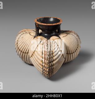 Aryballos en terre cuite (fiole à huile) sous forme de trois coques fin 6th siècle avant J.-C. grec, Attique inscrit sur la lèvre, 'le garçon est juste'uch petites bouteilles ont tenu l'huile d'olive utilisée par les athlètes pour se nettoyer après l'exercice.Ce vase exquis est orné de lignes noires et rouges qui accentuent les bords extérieurs des trois coquilles.Aryballos en terre cuite (fiole à huile) sous forme de trois coques.Grec, Attique. Fin du 6th siècle avant J.-C..Terre cuite.Archaïque.Vases Banque D'Images