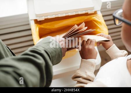 Vue de dessus gros plan de père et fils afro-américains mettant du papier dans des bacs de recyclage à la maison, espace de copie Banque D'Images