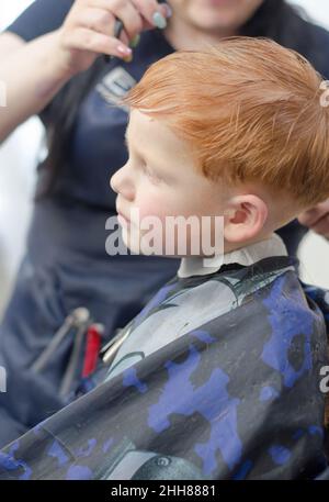 REDHEAD garçon de 4 ans dans une barbershop Banque D'Images