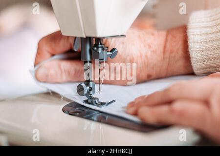 Gros plan de la couture des femmes à la main sur la machine à coudre. Banque D'Images