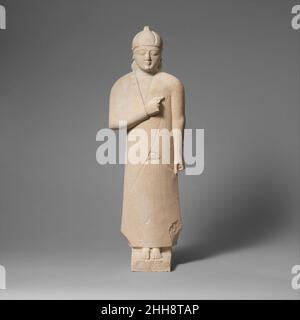 Statuette en calcaire d'un votaire mâle (adorateur) mi-6th siècle C.-B. Cypriote la figure porte un casque conique, dont la crête tombe à l'arrière.Statuette calcaire d'un votary mâle (adorateur) 242086 Banque D'Images