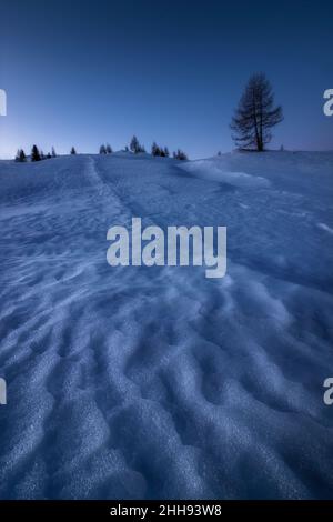 Formes créées par le vent dans la neige dans une matinée bleue à Cortina d'Ampezzo, dans les dolomites italiens.Mise au point de l'image empilée. Banque D'Images