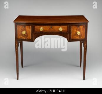 Dressing table 1800–1810 américaine dans la parlance de l’ébénisterie du début du XIXe siècle, cette « coiffeuse de dame » est dotée d’une « arche simple devant » – une conception plus coûteuse sur le modèle basique à façade droite avec un seul long tiroir.Selon le concepteur de meubles anglais George Heplewhite, les tiroirs des tables de dressing ont été cloisonnés pour accueillir des « peignes, poudres, essences, coussins à broches et autres équipements nécessaires ».Table à garniture.Américain.1800–1810.Acajou, placage bouleau, tilleul avec pin blanc.Fabriqué à Portsmouth, New Hampshire, États-Unis Banque D'Images