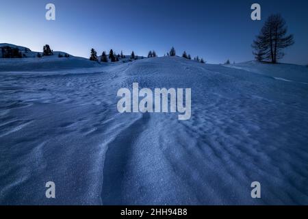 Formes créées par le vent dans la neige dans une matinée bleue à Cortina d'Ampezzo, dans les dolomites italiens.Mise au point de l'image empilée. Banque D'Images