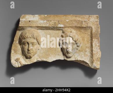 Haut d'un relief funéraire en marbre avec des bustes de portrait d'un jeune homme et d'une femme âgée ca.A.D. 138–141 Roman bien qu'il soit brisé en dessous, assez de ce relief est préservé pour montrer que l'homme porte un manteau, peut-être un lacerna, et la femme porte ce qui est probablement un palla.Les caractéristiques communes de la paire suggèrent qu'ils sont fils et mère.La coiffure de la femme est proche de celle portée par Faustina l'ancien, l'épouse de l'empereur Antoninus Pie.Haut d'un relief funéraire en marbre avec des bustes de portrait d'un jeune homme et d'une femme âgée.Romain ca.A.D. 138–141.Marbre.Mi-impérial, Antonine. Banque D'Images