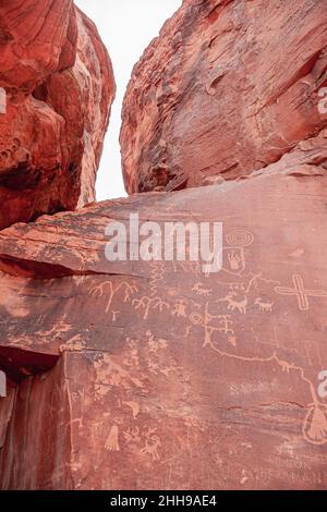 Overton, Nevada, États-Unis - 24 février 2010 : Vallée de feu.Gros plan des anciens messages pictogrammes rayés sur les surfaces rouges du roc dans le canyon. Banque D'Images