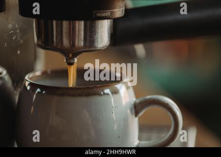 Espresso versé dans une tasse blanche.Processus de fabrication de l'espresso.Café style de vie.Machine à espresso de haut en bas. Banque D'Images