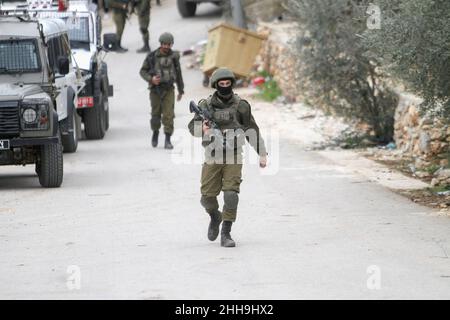 Salfit, Palestine.23rd janvier 2022.Des soldats israéliens patrouillent dans les rues du village de Qira après que des colons juifs aient écrit l'étoile rouge de David sur les murs de la maison du village.Tard dans la nuit, les colons juifs israéliens ont peint en hébreu des slogans appelant à la vengeance et à l'incitation sur les murs des maisons palestiniennes et ont vandalisé leurs voitures près du gouvernorat de Salfit en Cisjordanie.Crédit : SOPA Images Limited/Alamy Live News Banque D'Images