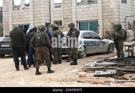 Salfit, Palestine.23rd janvier 2022.Les soldats israéliens sont vus à l'endroit où les voitures palestiniennes ont été vandalisées avec des peintures en aérosol et des slogans comme 'magen David Adom'.Tard dans la nuit, les colons juifs israéliens ont peint en hébreu des slogans appelant à la vengeance et à l'incitation sur les murs des maisons palestiniennes et ont vandalisé leurs voitures dans le village de Qira, près du gouvernorat de Salfit en Cisjordanie.Crédit : SOPA Images Limited/Alamy Live News Banque D'Images