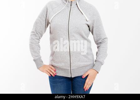 Jeune fille vêtements taille basse portant un sweat-shirt en coton vierge avec zone pour votre logo, maquette de sweat à capuche gris pour femmes, mur blanc à l'arrière-plan avec co Banque D'Images