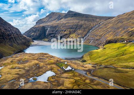 Photo aérienne d'une église pittoresque en face d'un petit lac, à Saksun, îles Féroé. Banque D'Images