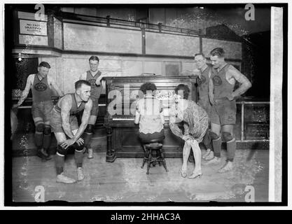 1926 - Miss Vivian Marinelli donnant des leçons de danse à Charleston aux joueurs de basket-ball du Palace Club, Washington, D.C., entrée dans la ligue américaine de basket-ball.De gauche à droite : Kearns, Manager Kennedy, Conway, femme jouant du piano, Mlle Marinelli,Grotty, et Saunders Banque D'Images