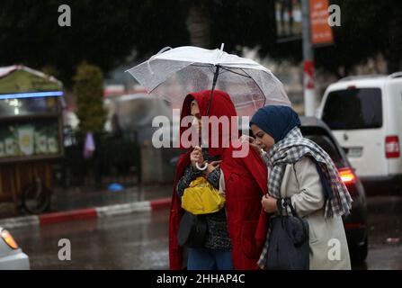 Naplouse.23rd janvier 2022.Des femmes palestiniennes marchent dans une rue au milieu de la pluie dans la ville de Naplouse, en Cisjordanie, le 23 janvier 2022.Credit: Ayman Nobani/Xinhua/Alamy Live News Banque D'Images