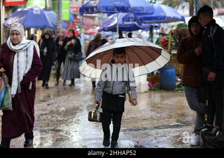 Naplouse.23rd janvier 2022.Un garçon palestinien vend du thé dans une rue au milieu de la pluie dans la ville de Naplouse, en Cisjordanie, le 23 janvier 2022.Credit: Ayman Nobani/Xinhua/Alamy Live News Banque D'Images