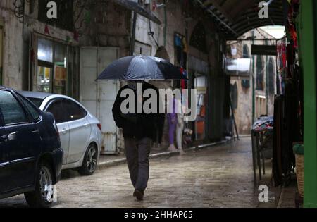 Naplouse.23rd janvier 2022.Un palestinien marche dans une rue au milieu de la pluie dans la ville de Naplouse, en Cisjordanie, le 23 janvier 2022.Credit: Ayman Nobani/Xinhua/Alamy Live News Banque D'Images