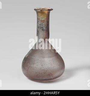 Flacon de parfum en verre 1st Century A.D. Roman petit fond de parfum sans couleur avec teinte bleuâtre pâle et strié de violet.rebord biseauté, plié, sur, et dans; col cylindrique grand,Outil autour de la base ; corps conique avec côtés arrondis tournés vers un fond plat et inégal. Rainure horizontale découpée en roue autour du corps. Intact ; nombreuses bulles et stries soufflantes ; morcellement, piqûres et irising sur le bord et l'intérieur du cou.Flacon de parfum en verre 239753 Banque D'Images