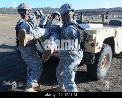 Des soldats du bataillon de la police militaire de 525th chargent un camarade blessé dans un véhicule tactique Banque D'Images