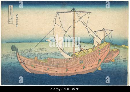 À la mer au large de Kazusa (Kazusa no kairo), de la série trente-six vues du Mont Fuji (Fugaku sanjūrokkei) ca.1830–32 Katsushika Hokusai Japonais le mât et les voiles de la grande jonque au premier plan créent un jeu intéressant de formes triangulaires qui reflètent et encadrent la forme de Fuji dans la distance.La teinte bleu profond de l'eau au premier plan de l'impression trouve un contre-point visuel dans la bande bleue inky qui atteint l'horizon et le ciel.Cette répétition de couleur sert à aplatir la scène, en reliant la distance entre proche et lointain.Un rivage et de minuscules voiliers gamme alon Banque D'Images