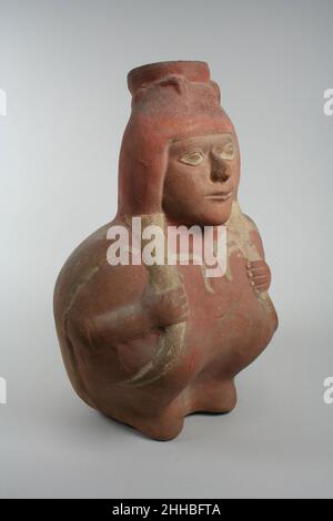 Figure jar 3rd–6th Century Moche cette bouteille en céramique représentant une figure assise avec les genoux dressés a été produite entre le troisième et le sixième siècles après J.-C. sur la côte nord du Pérou par les potiers de la culture Moche.Les Moche sont bien connus pour leurs vaisseaux sculptés vivants en forme d'animaux et de plantes, ainsi que pour leurs vaisseaux avec des scènes détaillées de figures humaines et surnaturelles s'engageant dans une variété d'activités.Ce vaisseau, avec ses traits faciaux délicatement modélisés et ses longs cheveux rassemblés de chaque côté de la tête, représente probablement une femelle.Les détails de la surface ont été peints à l'aide de crème Banque D'Images