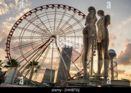 La grande roue et la statue d'Ali et de Nino sur le remblai de Batumi, en Géorgie Banque D'Images