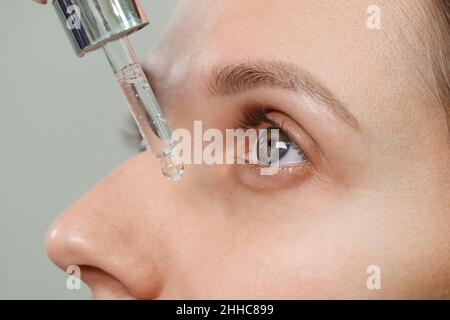 Appliquer le sérum d'huile à partir de la pipette.Produit cosmétique naturel biologique pour les soins du visage et la régénération de la peau autour de la zone des yeux. Gros plan extrême Banque D'Images