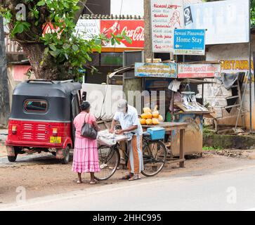 Vendeur de loterie vendant des billets de loterie de son vélo à Pinnawala, province de Rambukkana, Sri lanka. Banque D'Images