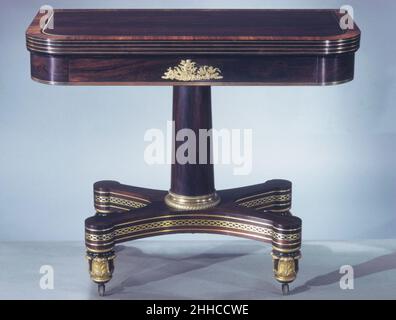 Table de cartes ca.1825 attribuées à l'atelier de Duncan Phyfe Scottish avec leur forme audacieuse mais simple, ces tables à cartes à piliers (voir aussi 68.94.1) aux coins arrondis anticipent le style grec simplifié de la 1830s.Peut-être fabriqués dans l'atelier de Duncan Phyfe, ils sont dans le style de restauration français, qui a coïncidé aux États-Unis avec le mode grec de renouveau en architecture.Plaquées de bois de rose exotique et incrustées de laiton, les tables sont enrichies d'ornements en laiton doré centrés sur les tabliers et de pieds de style ancien bronzés et dorés.Carte Tableau 1451 Banque D'Images