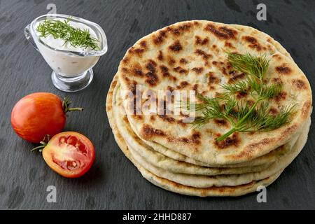 Pain fin avec fromage et herbes et sauce au yaourt Banque D'Images