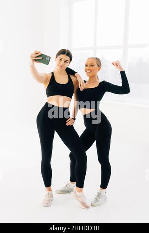 Deux femmes se rencontrent à la salle de gym, faisant le selfie photo Banque D'Images