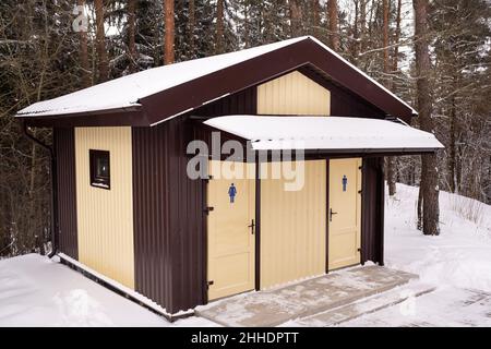 Toilettes pour hommes et femmes dans une forêt enneigée. Banque D'Images