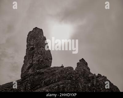 Une figure solitaire se trouve sur l'éperon rocheux de l'ancien homme de Storr sur la péninsule Trotternish, île de Skye, Écosse, Royaume-Uni Banque D'Images