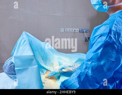 Dans la salle d'opération de l'hôpital équipe diversifiée de chirurgiens professionnels et d'infirmières Suture Winound après une chirurgie réussie. Banque D'Images