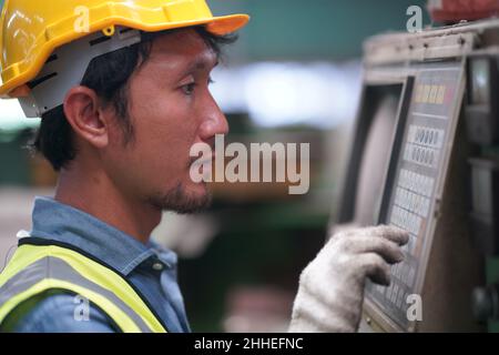 Homme ingénieur métallurgiste industriel expérimenté opérateur technicien travailleur en sécurité casque dur travaillant sur machine de tour, homme professionnel en indést Banque D'Images