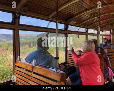 Royaume-Uni, pays de Galles, Merthyr Tydfil, Brecon Mountain Railway, passagers en train pour Torpantau, prenant une photo de téléphone portable de la fenêtre du train Banque D'Images