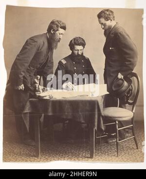 Planification de la capture du stand 1865 Alexander Gardner American, Scottish la relation à long terme d’Alexander Gardner avec le gouvernement fédéral et l’Armée du Potomac lui a donné un accès sans égal à des sujets que d’autres photographes n’avaient pas pu atteindre, en particulier dans les jours qui ont suivi l’assassinat du président par John Wilkes Booth.Ici, le Colonel Lafayette Baker, directeur des services secrets, est assis et étudie des cartes de la région où Booth était censé se cacher dans le Maryland ou la Virginie.Le portrait, sous forme de gravure en bois, illustre un long article publié par Harper’s Weekly le 13 mai 1865.ACC Banque D'Images