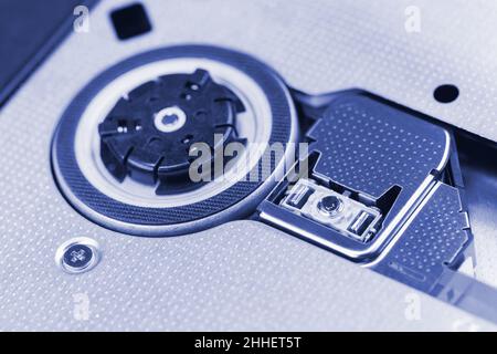 Structure interne d'un lecteur de disque optique.Axe du moteur et tête laser.Photographie macro teintée en bleu Banque D'Images