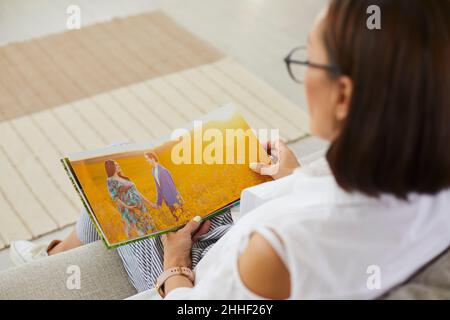 Femme regardant à travers des photos de maternité photoshoot dans un album de famille ou un photolivre Banque D'Images