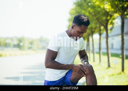 L'homme a une douleur sévère dans les genoux et les muscles de jambe après l'entraînement et la course, la douleur de spasme Banque D'Images