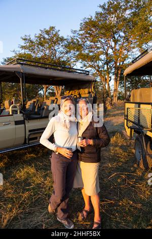 Deux femmes, une femme mûre et sa mère, debout côte à côte au coucher du soleil sur le safari. Banque D'Images