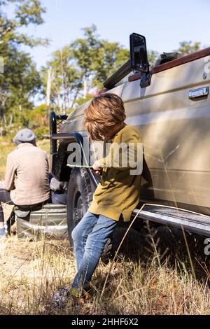 Un garçon par une jeep safari jouant avec un jouet Banque D'Images