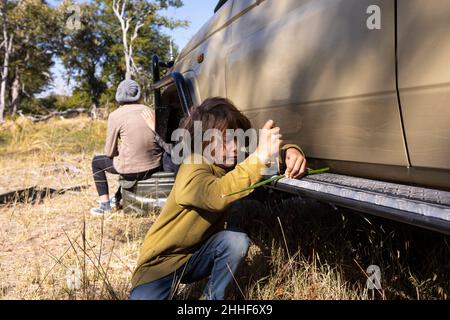 Un garçon par une jeep safari jouant avec un jouet Banque D'Images