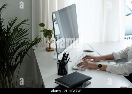 Gros plan sur les mains d'une femme qui tapent sur le clavier de l'ordinateur à l'intérieur.Homme d'affaires travaillant au bureau ou étudiant parcourant les informations Banque D'Images