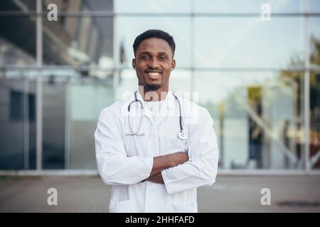 Portrait d'un médecin africain regardant l'appareil photo et souriant devant la clinique Banque D'Images