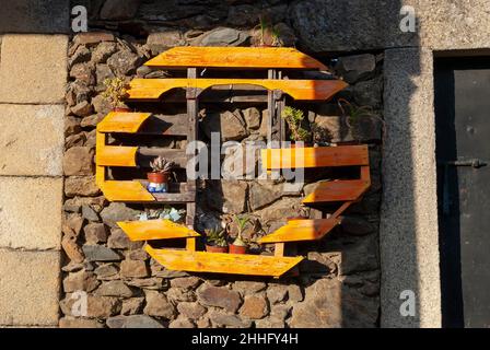 idée de recyclage palette industrielle comme semoir avec des plantes sur mur rustique en pierre Banque D'Images