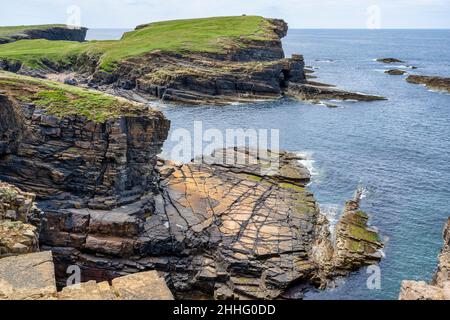 Vue à travers l'entrée abritée jusqu'au promontoire de Brough of Bigging sur la côte de Yesnaby, sur la côte ouest de Mainland Orkney, en Écosse Banque D'Images