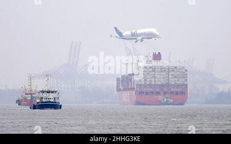 Hambourg, Allemagne.24th janvier 2022.Un avion de transport Airbus de type Beluga survole un énorme navire à conteneurs de la compagnie maritime Hamburg Süd sur l'Elbe à l'approche du site de l'usine de Finkenwerder.L'Elbe est tout à fait clair pour les nouveaux brouillons après l'approfondissement récent du canal de navigation.Credit: Marcus Brandt/dpa/Alay Live News Banque D'Images