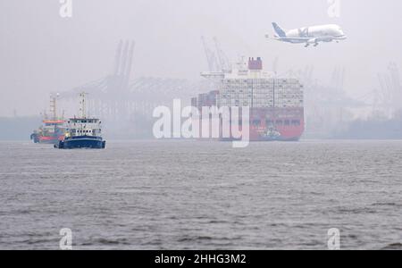 Hambourg, Allemagne.24th janvier 2022.Un avion de transport Airbus de type Beluga survole un énorme navire à conteneurs de la compagnie maritime Hamburg Süd sur l'Elbe à l'approche du site de l'usine de Finkenwerder.L'Elbe est tout à fait clair pour les nouveaux brouillons après l'approfondissement récent du canal de navigation.Credit: Marcus Brandt/dpa/Alay Live News Banque D'Images